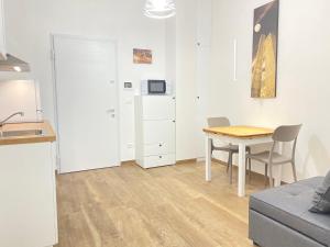 a living room with a table and a kitchen at Suite Emilia 4 in Bologna +9 photos
