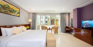 a hotel room with a large bed and a television at White Lotus Hotel Saigon in Ho Chi Minh City