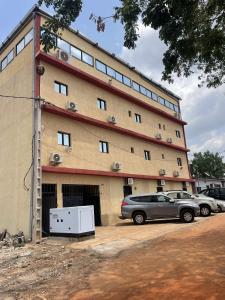 Résidences hôtels sibontour في ياموسوكرو: مبنى به سيارة متوقفة أمامه