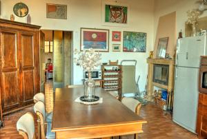 a dining room with a table and a refrigerator at Palazzo Poli centro storico con vista panoramica in Colle Val D'Elsa