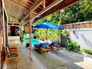 a patio with a table and chairs and an umbrella at Villa Bambu Private Pool in Uluwatu +17 photos