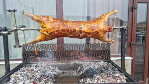 a chicken is being fried on a grill at Conca Verde Râșnov in Râşnov