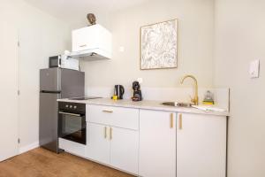 a kitchen with white cabinets and a stainless steel refrigerator at L'Antique Plaza, Appartement atypique et unique avec balnéo, proche centre et plage in Le Portel +17 photos