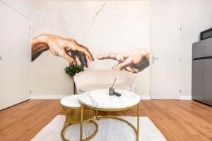 a living room with a wall mural of two hands at L'Antique Plaza, Appartement atypique et unique avec balnéo, proche centre et plage in Le Portel