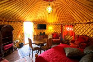 een slaapkamer met een bed en een tafel in een yurt bij JURTE - Traumhafter Meerblick, beheizter Pool, Sauna, Billiard, Tischtennis, Garten in La Asomada