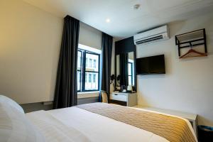 Postel nebo postele na pokoji v ubytování De Quinton Hotel