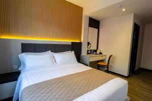 Postel nebo postele na pokoji v ubytování De Quinton Hotel