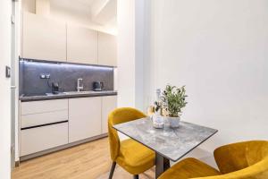 a kitchen with a table and chairs and a sink at ZAGABRIA - Modern Boutique Studios by Main Square in Zagreb