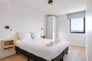 a bedroom with a large white bed with towels on it at Maison Sebastian in Nieuwpoort