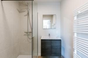 a bathroom with a shower and a sink and a mirror at Maison Sebastian in Nieuwpoort +9 photos