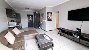 a living room with a couch and a flat screen tv at Stone's Palace in Edenvale