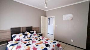 a bedroom with a bed with a comforter on it at Stone's Palace in Edenvale