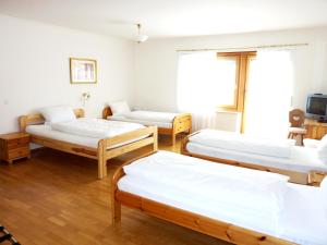 ラウッツェンハウゼンにあるエアポート ホテル フォーチュナのベッド3台とテレビが備わる客室です。