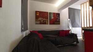 a living room with a gray couch and red pillows at House on the Top in Patra