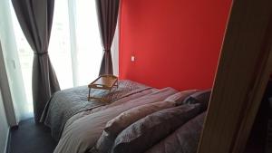 a bedroom with a bed with a red wall at House on the Top in Patra