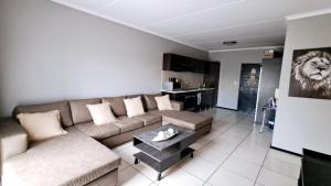 a living room with a couch and a lion on the wall at Stone's Palace in Edenvale