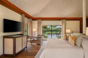 a bedroom with a large bed and a television at The Oberoi Vindhyavilas Wildlife Resort, Bandhavgarh in Tāla
