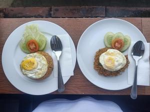 two plates of food with eggs and vegetables on them at Asiana Lovina Hotel in Lovina