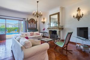 a living room with two white couches and a fireplace at Villa Mesquida in Portocolom
