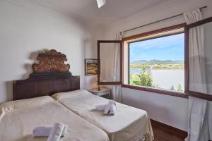 a bedroom with a bed and a large window at Villa Mesquida in Portocolom +38 photos