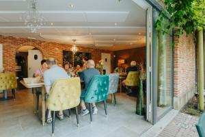 a group of people sitting at a table in a restaurant at B&B De Floreffe in Overpelt