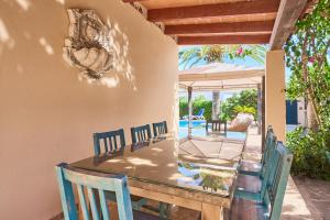 a patio with a table and chairs and a pool at Villa Mesquida in Portocolom