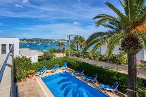 a swimming pool with chairs and a view of the water at Villa Mesquida in Portocolom