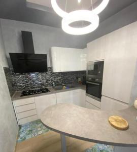 een keuken met een tafel en een fornuis bovenste oven bij Villa al mare in San Felice Circeo