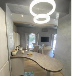 een woonkamer met een tafel en een kroonluchter bij Villa al mare in San Felice Circeo