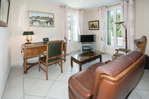 a living room with a couch and a desk at maison proche du marche - 8798 in Soulac-sur-Mer