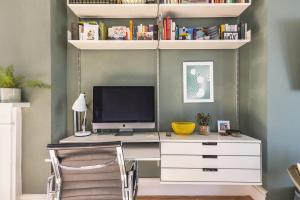 a desk with a computer on top of it at Leafy & Stylish Brixton Retreat in London