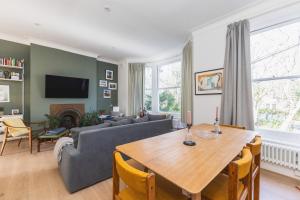 a living room with a table and a couch at Leafy & Stylish Brixton Retreat in London