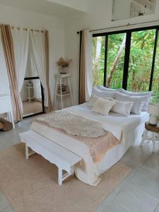 a white bed in a room with a large window at RP Botanical Park, Hotel & Resort in Tagbina +23 photos