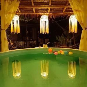 a pool table in a room with chandeliers at RP Botanical Park, Hotel & Resort in Tagbina