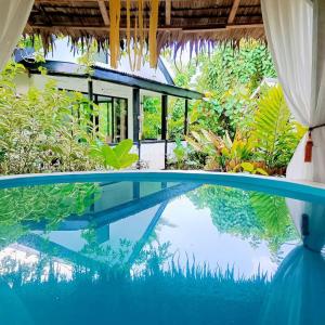 a swimming pool in front of a house at RP Botanical Park, Hotel & Resort in Tagbina