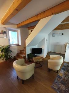 a living room with two chairs and a tv at Ferienwohnungen in kleiner historischer Altstadt in Sulzbach-Rosenberg