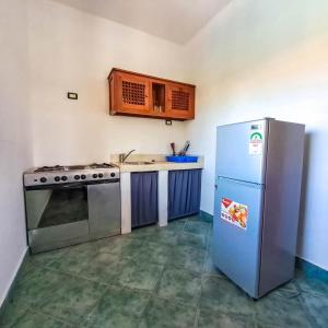 a kitchen with a stove and a refrigerator at Modern Girasoli Suites 01 in Malindi