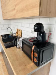a black microwave sitting on top of a kitchen counter at Twoje prywatne SPA - jacuzzi, sauna, tężnia solankowa in Kraków