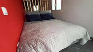 a bedroom with a bed with a gray comforter and blue pillows at House on the Top in Patra