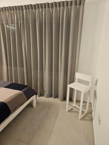 a bedroom with a bed and a chair in front of a curtain at White House in Civitanova Marche +43 photos