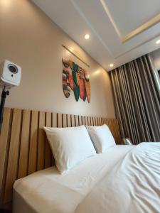 ハイフォンにあるmalela homestay 04の白いシーツと枕が備わったベッドのある寝室