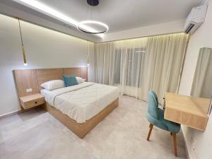 une chambre avec un lit, un bureau et une chaise dans l'établissement Property sisters, Elite garden view, Madinaty B6, au Caire