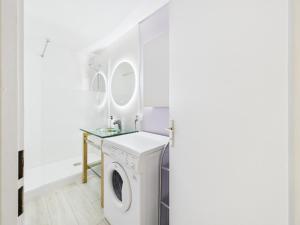 Un lavadero blanco con lavadora y secadora. en Appartement - balcon avec vue - piscine chauffée, en Guérande