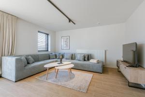 a living room with a couch and a tv at Maison Atlantis in Nieuwpoort