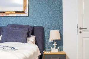 a bedroom with a bed with blue walls and a mirror at Alte Fischfabrik Am Leuchtturm in Lauterbach