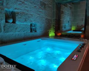a jacuzzi tub with blue lighting in a room at Dofely Suites - Gelso in Polignano a Mare