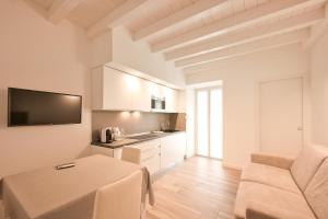 a kitchen and living room with a table and a couch at Sweetly apartment in the walled city with WiFi e AC in Como