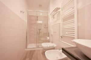 a white bathroom with a toilet and a shower at Sweetly apartment in the walled city with WiFi e AC in Como +11 photos