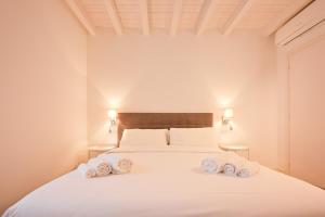 a bedroom with a white bed with towels on it at Sweetly apartment in the walled city with WiFi e AC in Como +11 photos