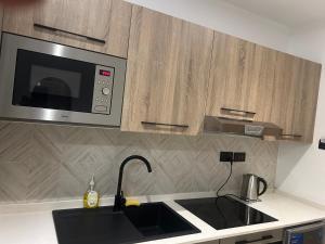 a kitchen with a sink and a microwave at KB Luxurious And Affordable Homes in Otele
